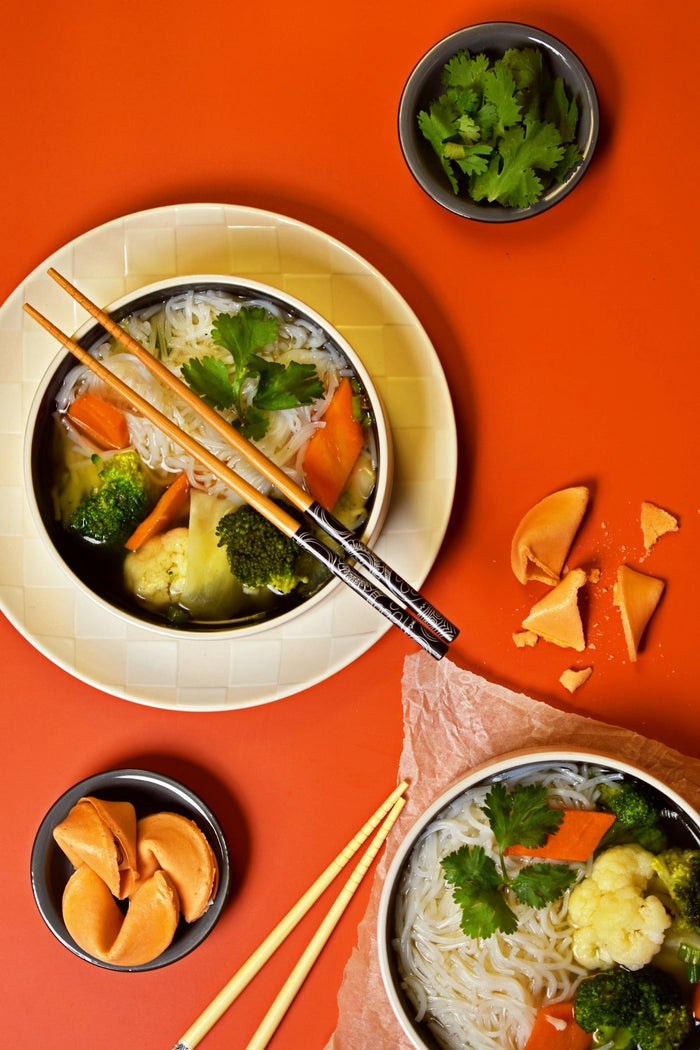 A table topped with bowls of food and chopsticks