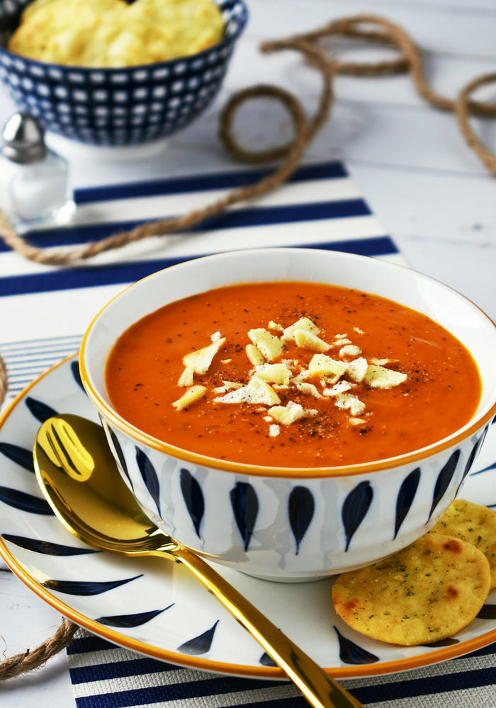 A bowl of soup on a plate with a spoon
