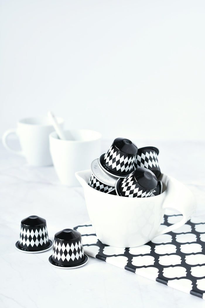 A white bowl filled with black and white cups