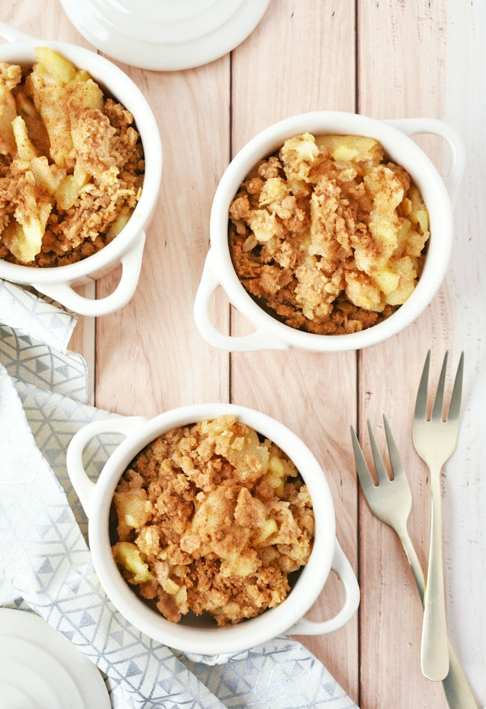 Three bowls of food on a wooden table