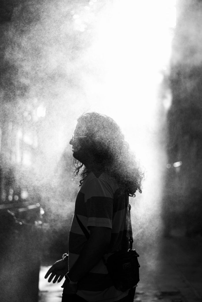 A woman walking down a street next to a fire hydrant