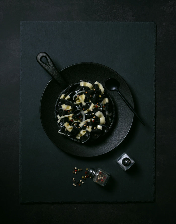 A black plate topped with food next to a camera