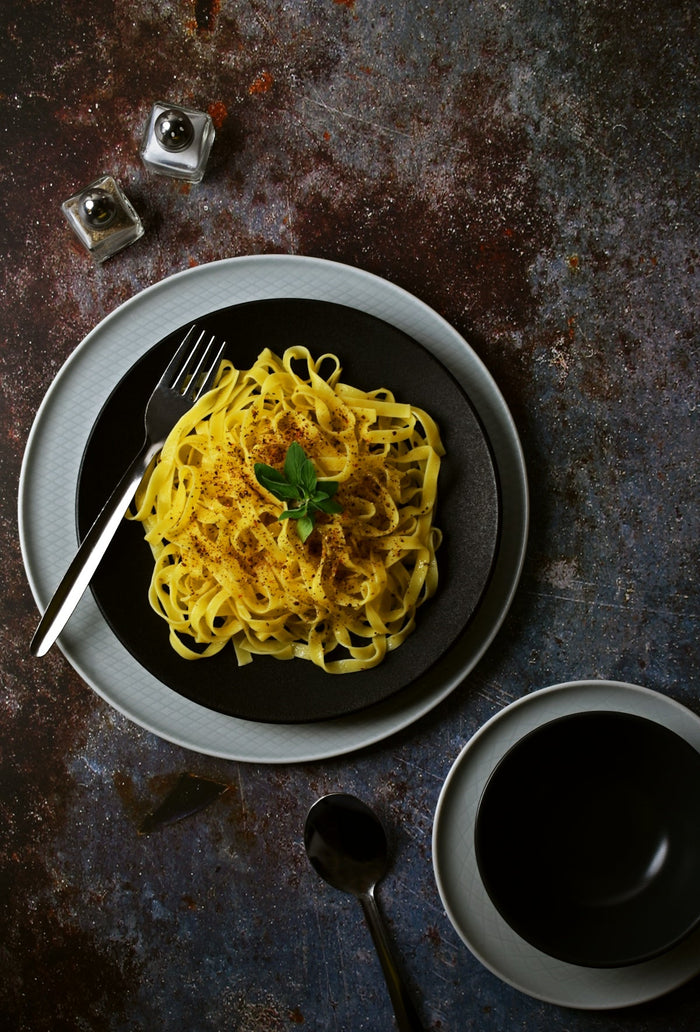 A plate of spaghetti and a cup of coffee